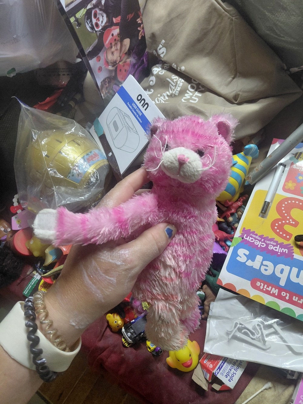 fluffy, pink-and-white striped plush kitty cat toy featuring white paws stained